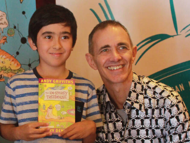 The 117-Storey Treehouse book signing Andy Griffiths and a child with a book.