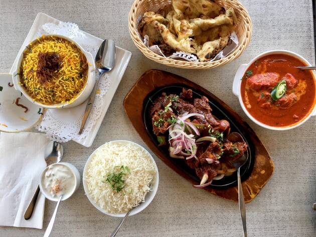 Not Just Curries Curries, rice and naan on a table