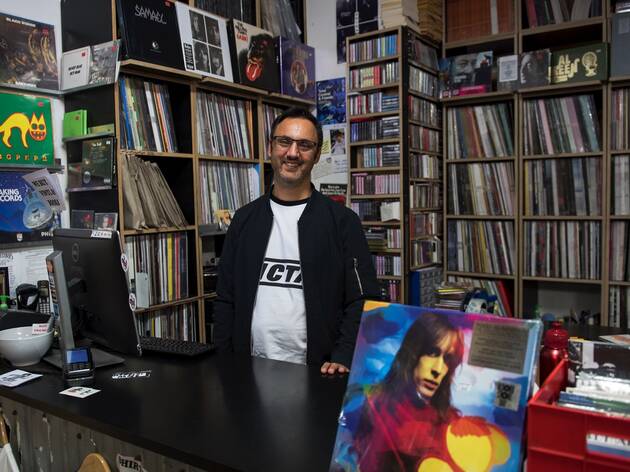 Repressed Records Owner of Repressed Records stands smiling behind the cashier desk