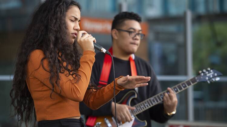 People singing and playing guitar on a stage at Make Music Day Parramatta.