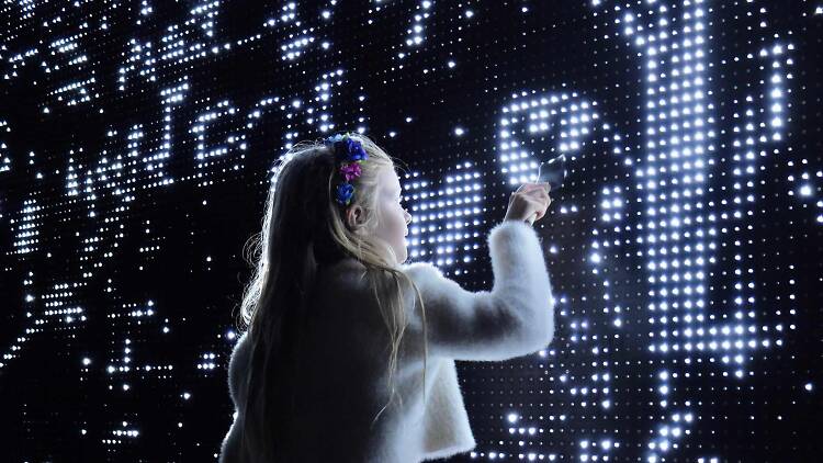 Small girl interacting with the Waterlight Graffiti installation