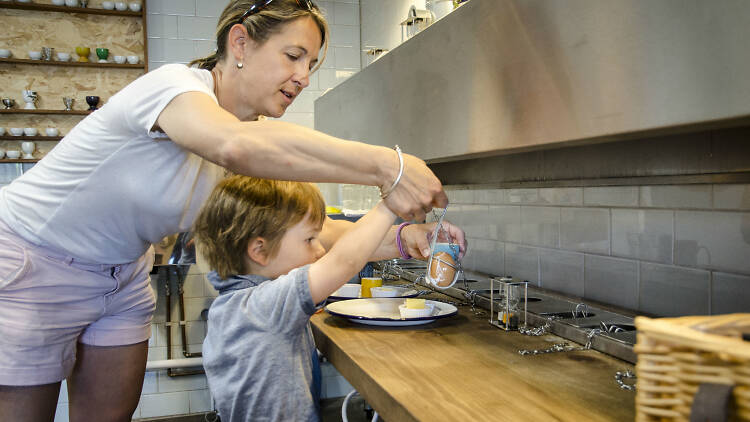 Two people making breakfast at Eggs & Bread