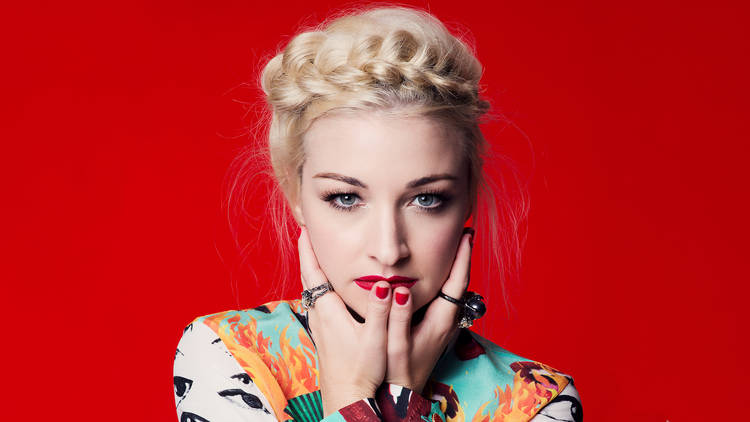 Kate Miller-Heidke infront of red background