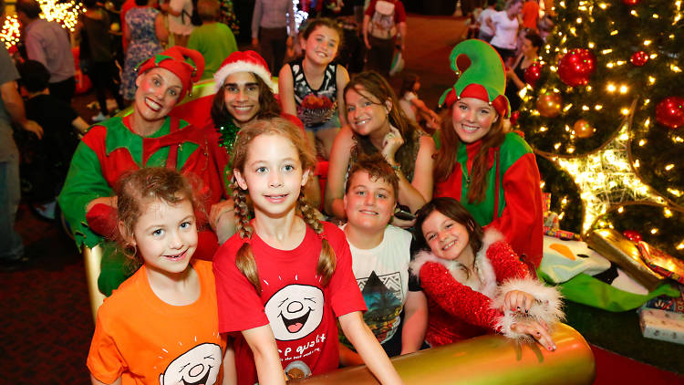 Kids and elves in a sleigh at the Santa Spectacular.