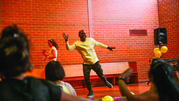 Man in yellow shirt leading dance class