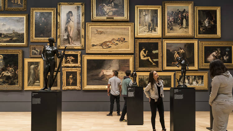 Room filled with paintings hung 'salon' style at the NGV