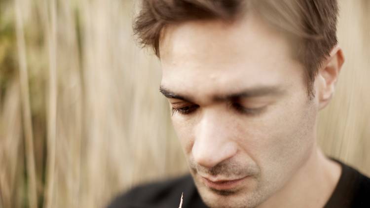 Jon Hopkins wearing a black top and looking down