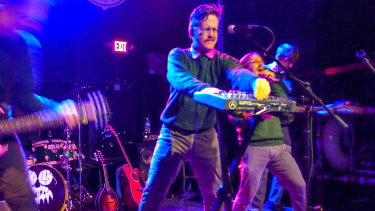 Men dressed as Ned Flanders playing enthusiastically on stage