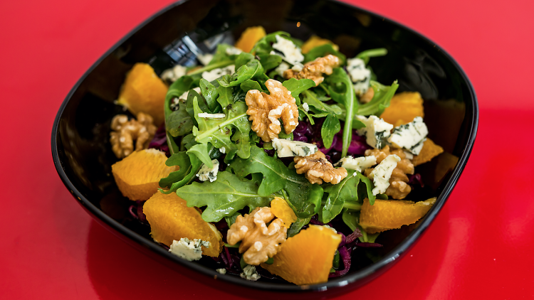 Salada de couve roxa, rúcula, laranja, nozes e queijo azul do Nômade