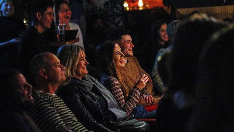 People in crowd laughing at comedy at Crab Lab