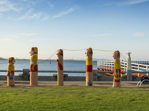 Bollard walk along Geelong's waterfront Five timber bollards painted to look like lifesavers on a lawn