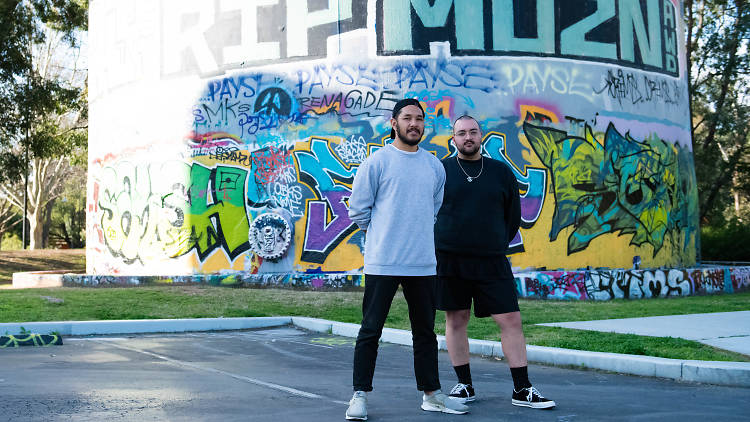 People standing in front of graffiti.