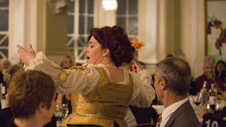 Opera Bites performers sing in a crowd of seated people.