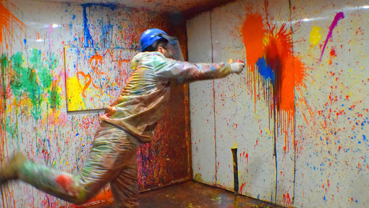 Person throwing paint at a wall