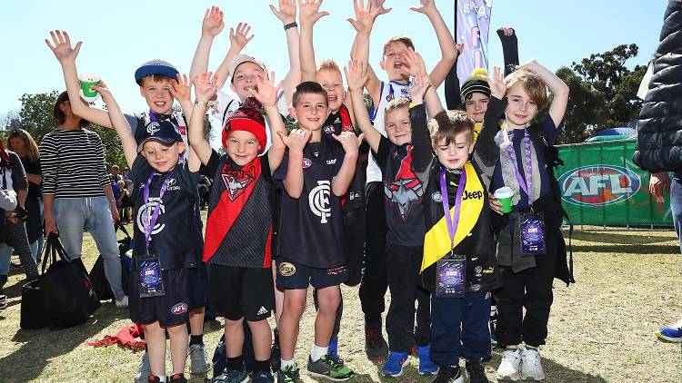 Kids in footy colours at the 2018 AFL Footy Festival at Yarra Park