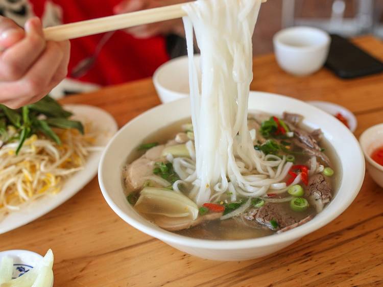 Person eating noodles at Pho Tam