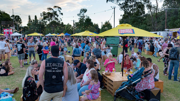 People gather around food trucks at festival