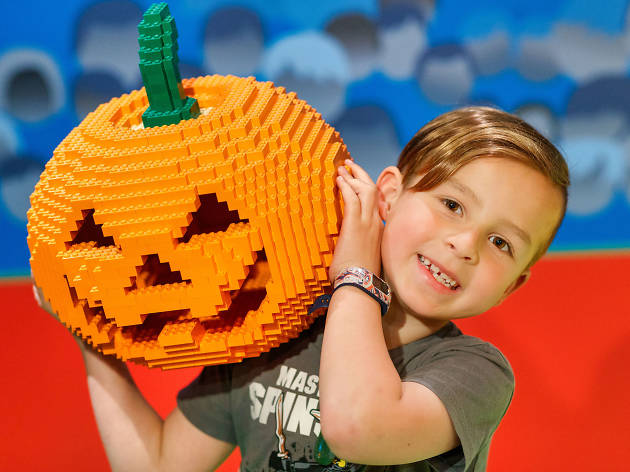 Legoland Halloween Child holding a jack-o-lantern made out of Lego
