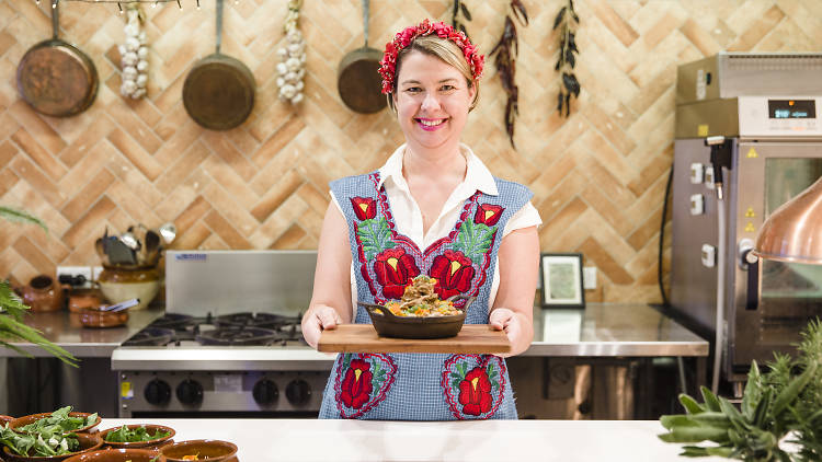 Rachel Jelley standing in an open kitchen holding a plate