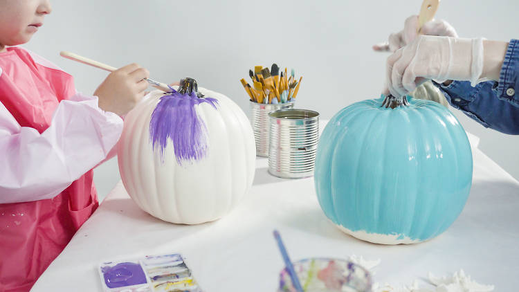 Kids painting pumpkins multicoloured. 