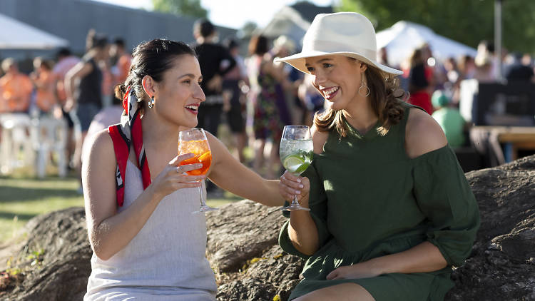 Two women drinking wine outdoors