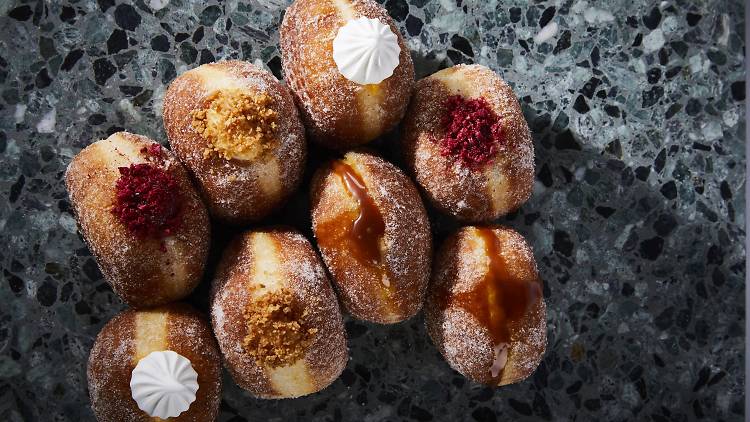 A group of donuts stuffed with different fillings and toppings