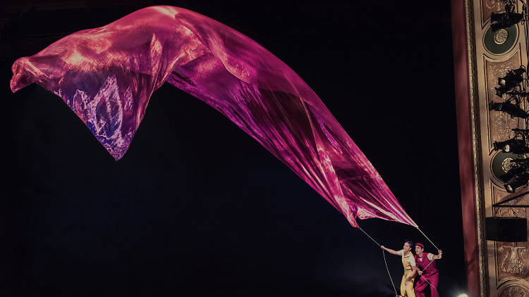 Characters in children's theatre show Air Play hold a long purple scarf in the wind.