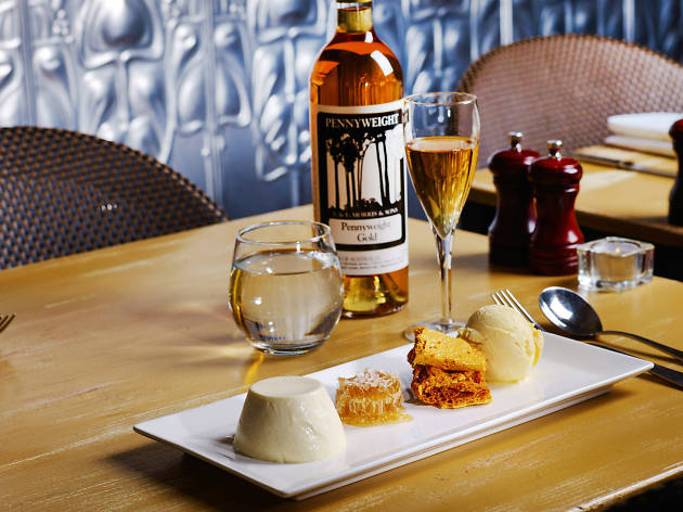 The Ox and Hound A table with a plate of ice cream, honeycomb and wine on it