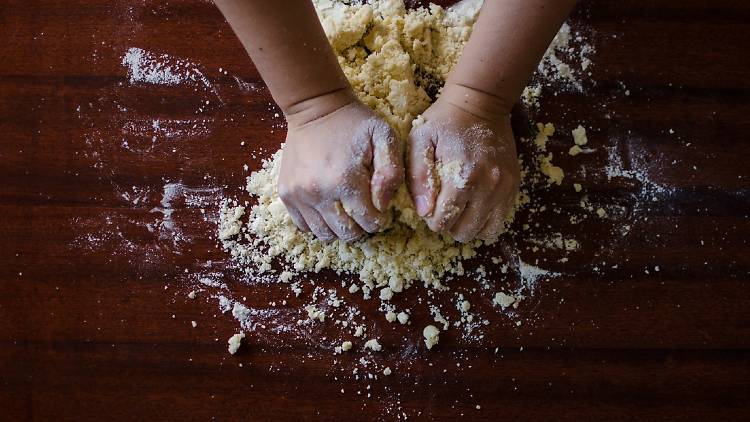Two hands pounding dough