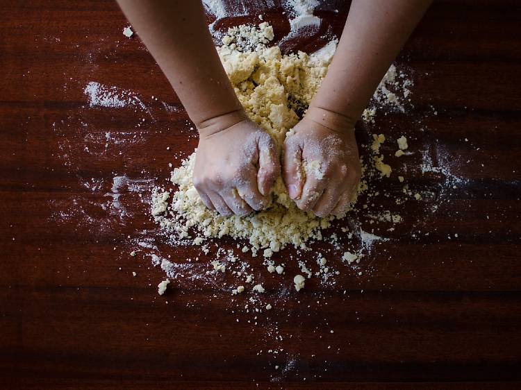 Two hands pounding dough