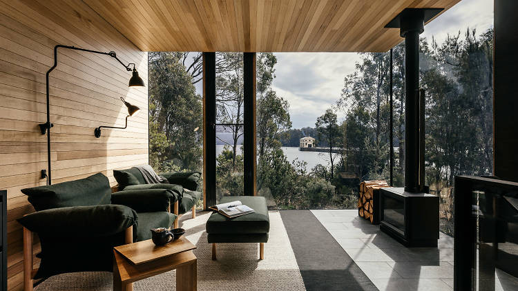 A room with plate glass windows looking out over a lake