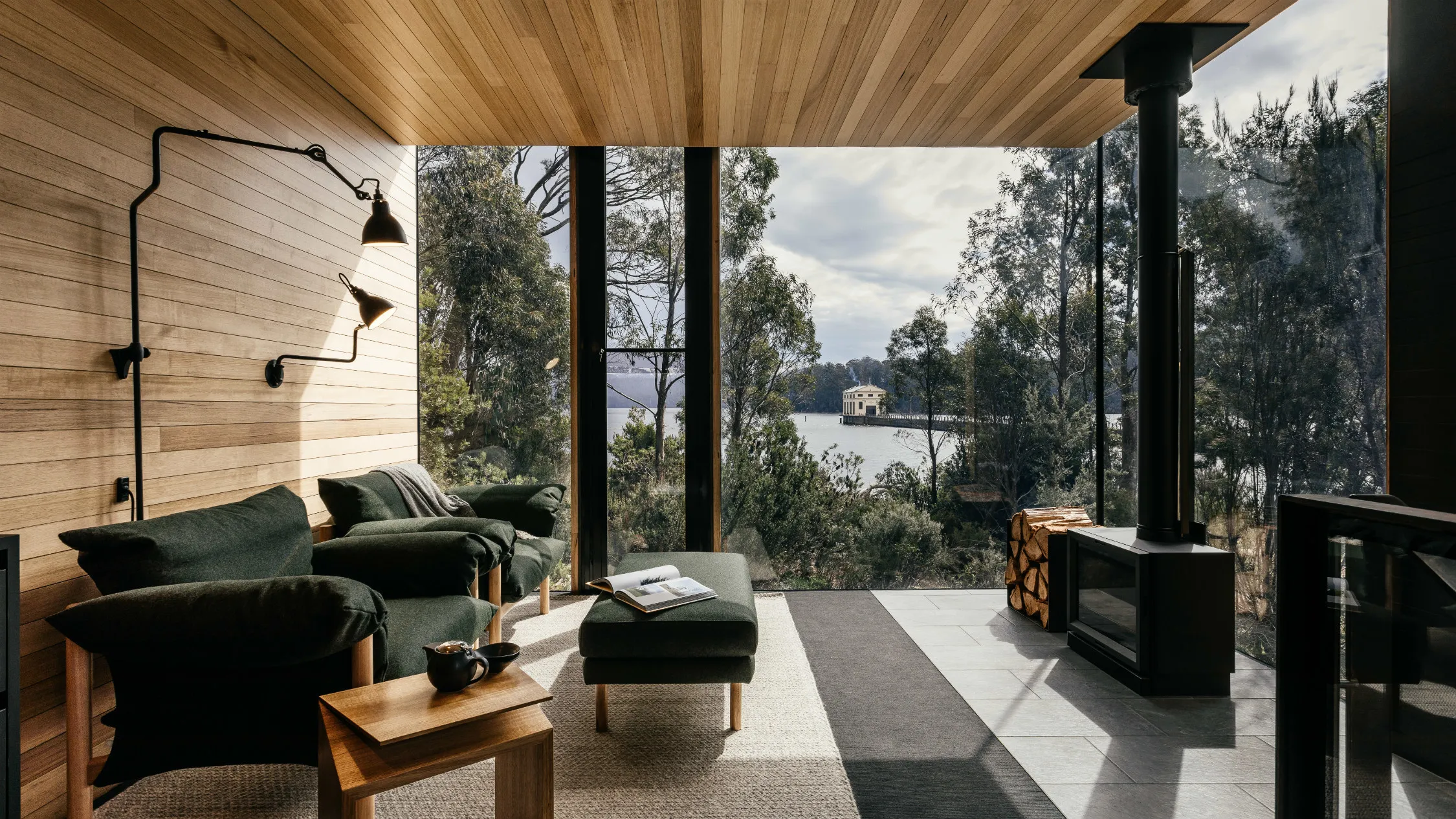 A room with plate glass windows looking out over a lake