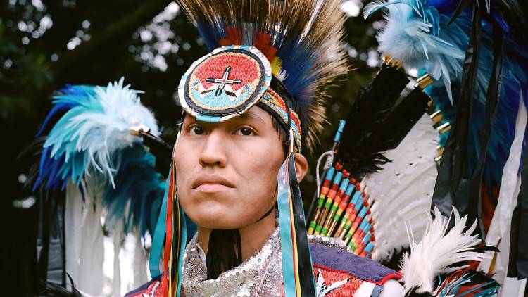 A man in traditional Native American costume and head piece. 