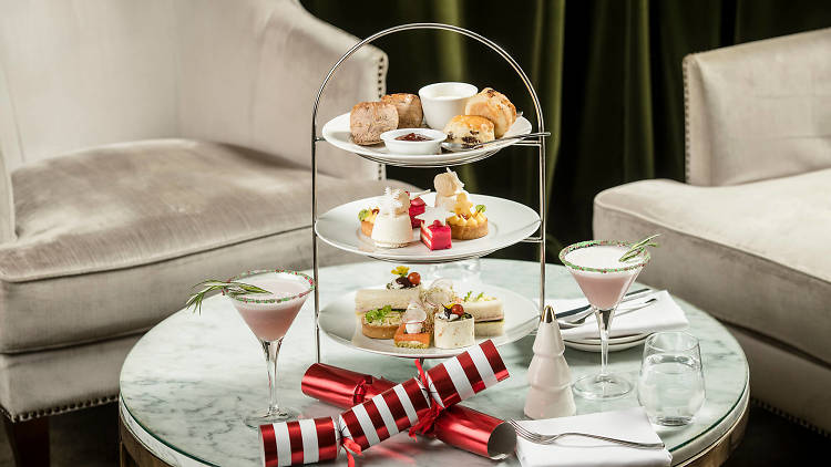 A Christmas-themed high tea on a three-tier stand on a coffee table