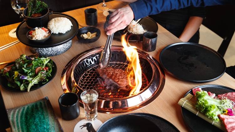 People grilling meat at the table Japanese-style