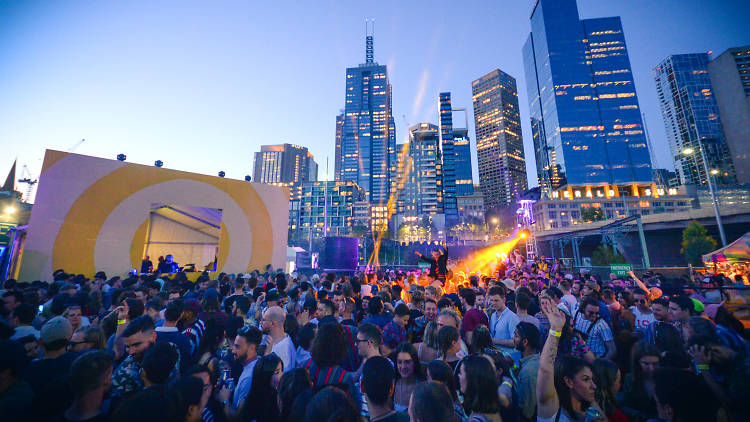 Crowd of people dancing with skyscrapers in background
