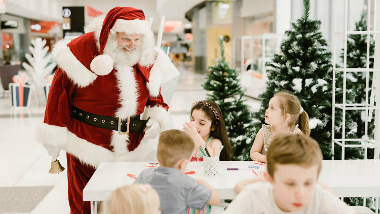 Santa saying hello to kids crafting