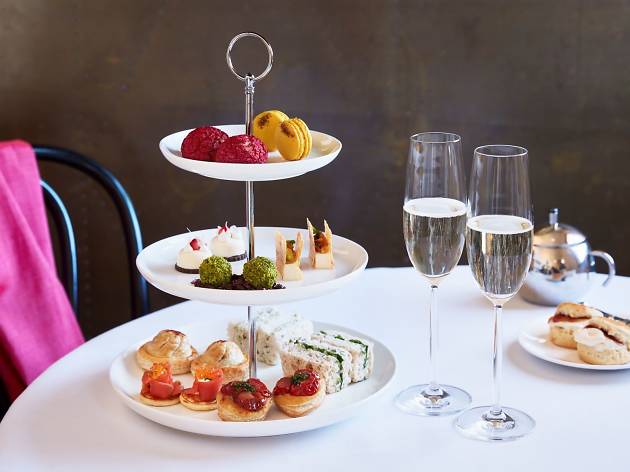 Estate Vaucluse House Three tiers of high tea snacks on a table with two glasses of Champagne