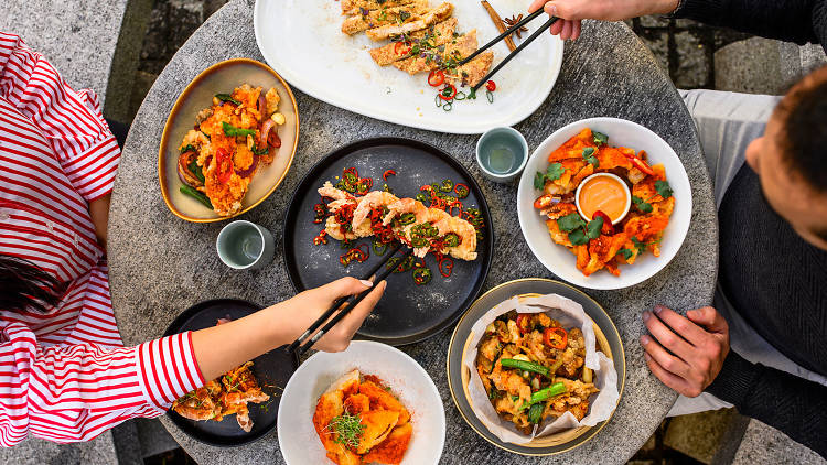 A birds eye view of a table laden with Chinese dishes.