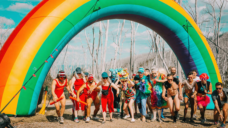 People gathered underneath an inflatable rainbow arch