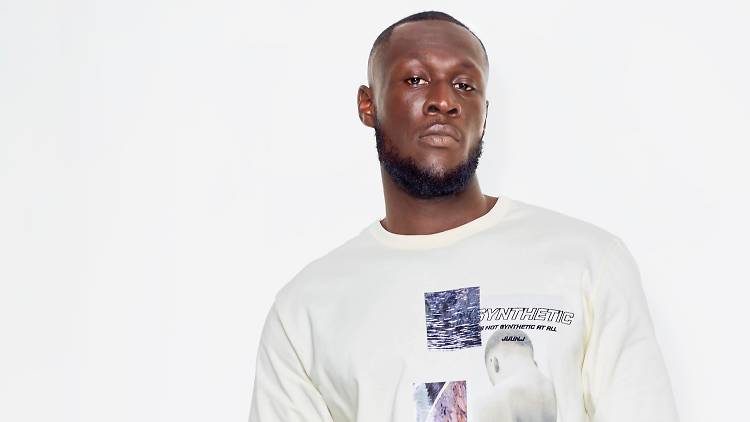 Rapper Stormzy stares down the camera in a white t-shirt.