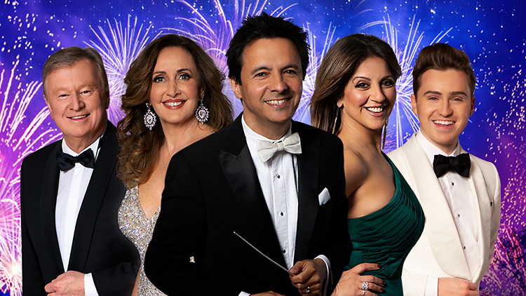 John Foreman and the line-up of the NYE Gala concert pose against a sky of fireworks. 