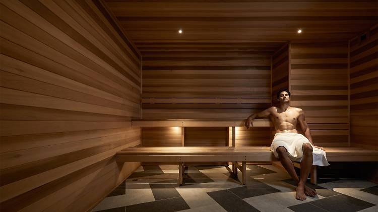 A man lounges in a sauna room.