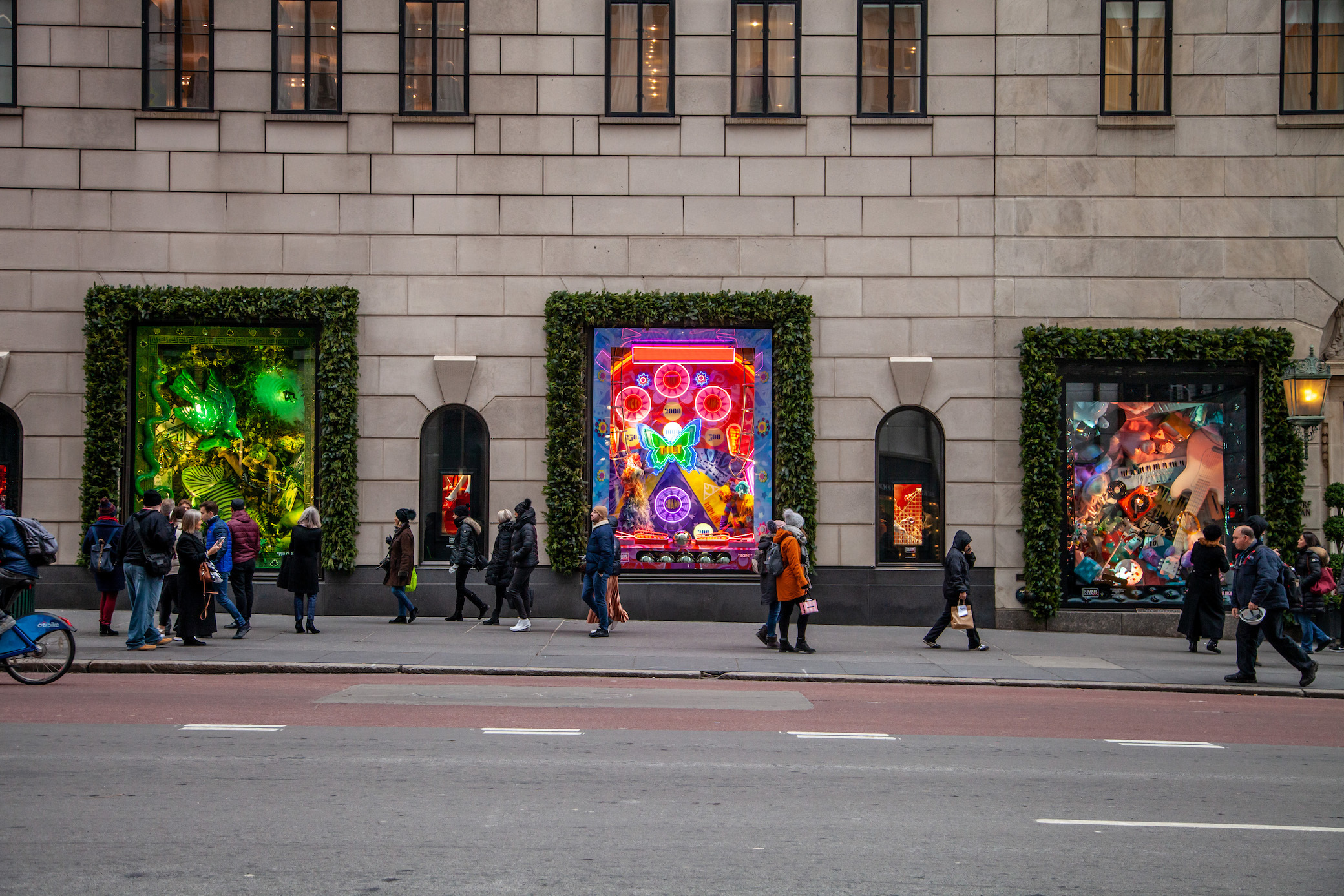 New York City, USA. 18th June, 2020. A reflection in Bergdorf Goodman  window of the newly opened (curbsidee pickup only) Louis Vuitton 5th Ave.  flagship store, decorated with a large rainbow in