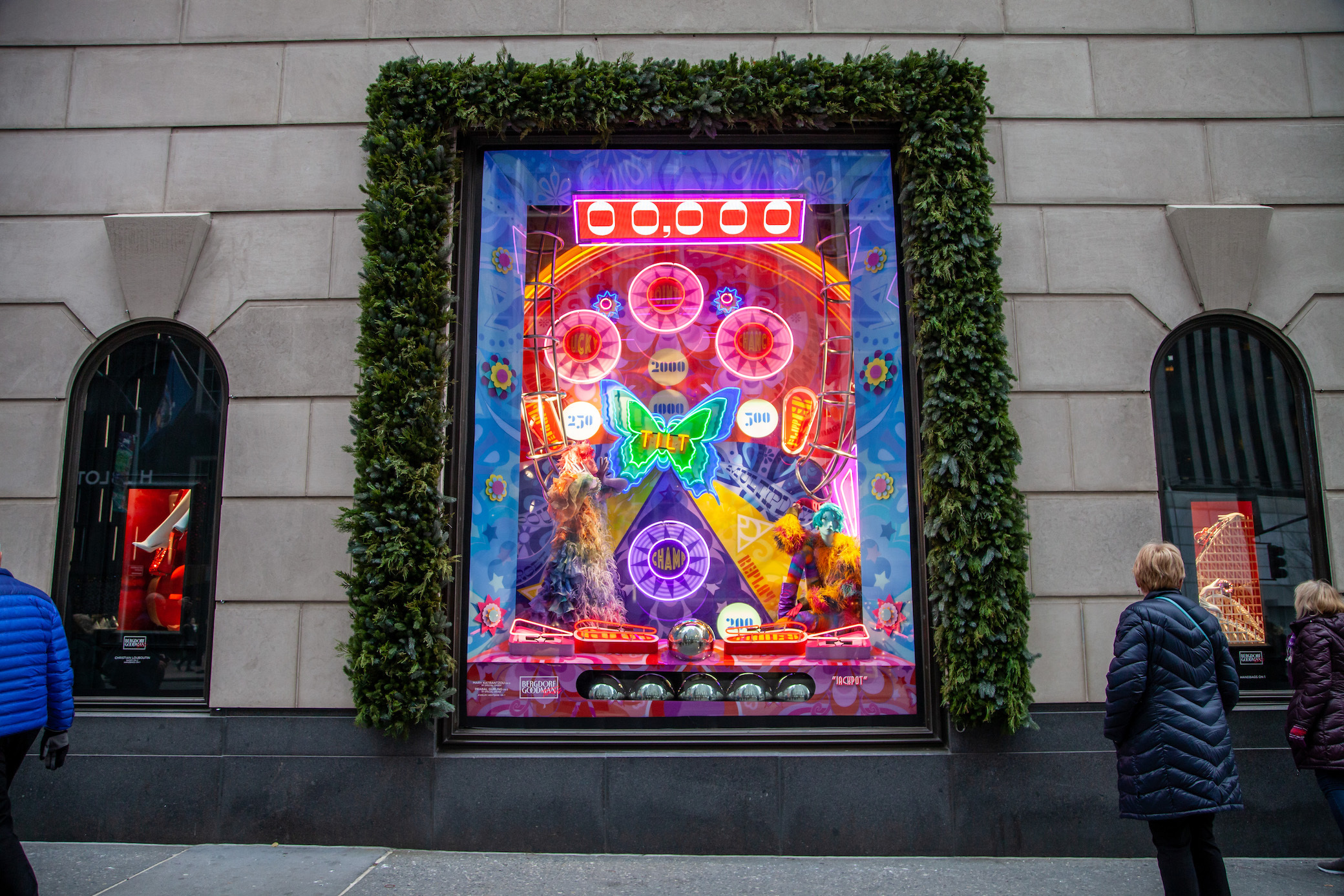 New York City, USA. 18th June, 2020. A reflection in Bergdorf Goodman  window of the newly opened (curbsidee pickup only) Louis Vuitton 5th Ave.  flagship store, decorated with a large rainbow in