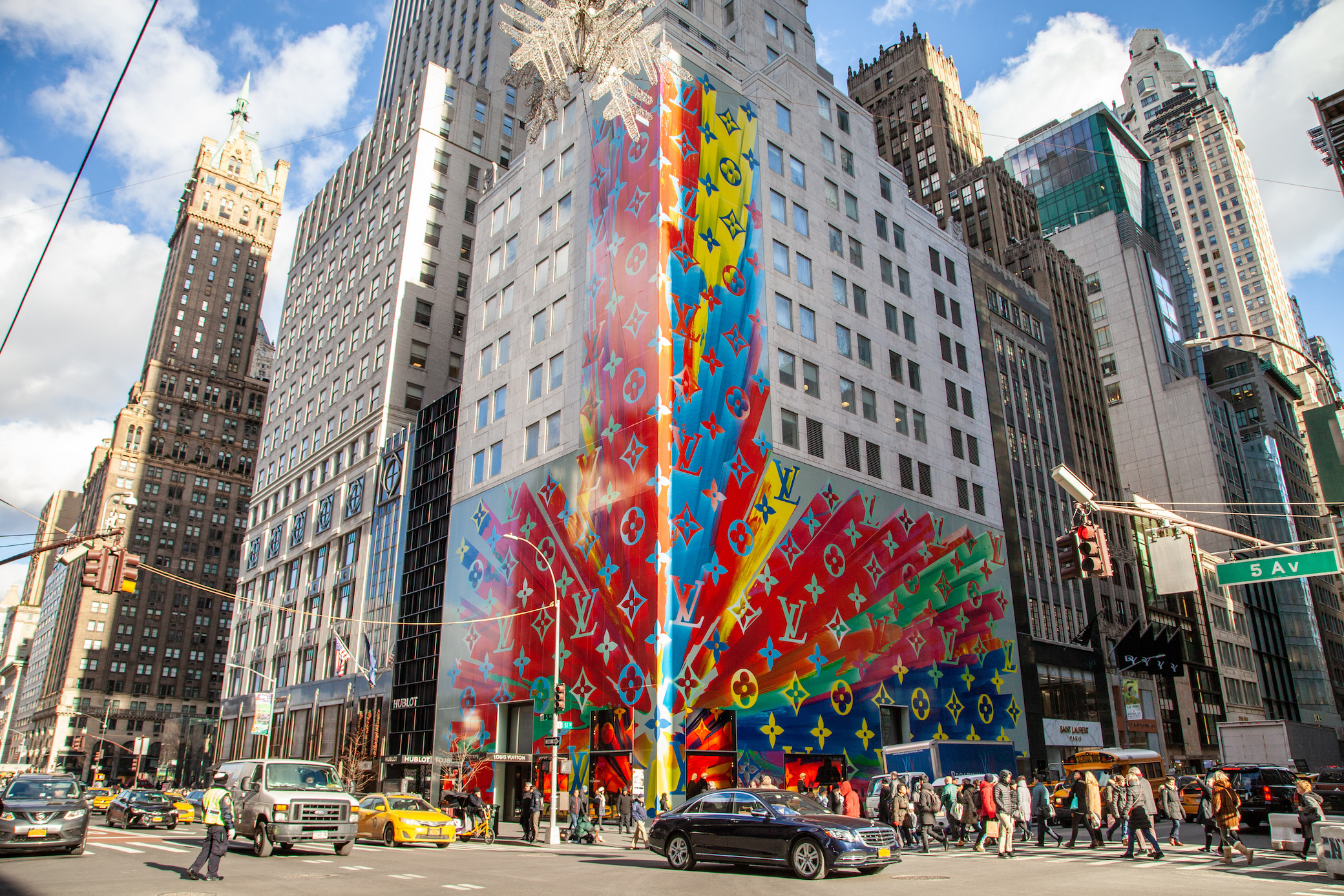 A reflection in Bergdorf Goodman window of the newly opened (curbsidee  pickup only) Louis Vuitton 5th Ave. flagship store, decorated with a large  rainbow in honor of “Pride Month”, New York, NY