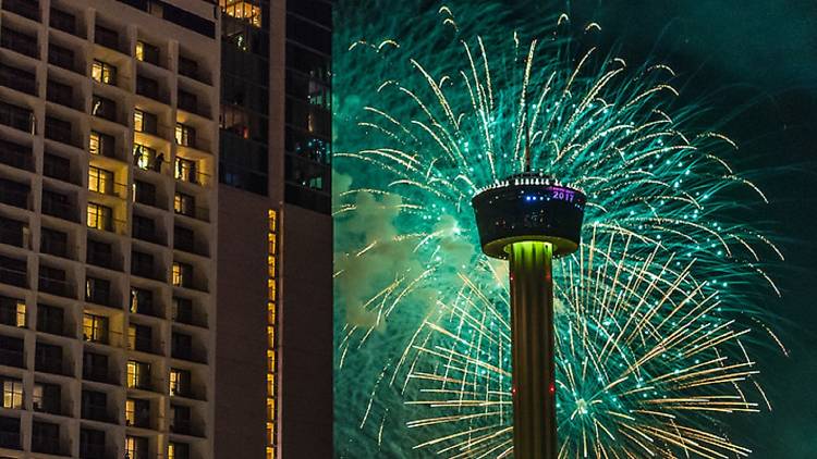 Green fireworks going off behind San Antonio's Tower of the Americas
