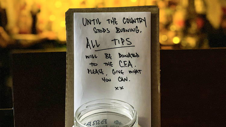A tip jar and a handwritten note saying "until the country stops burning, all tips will be donated the CFA. Please give what you can".