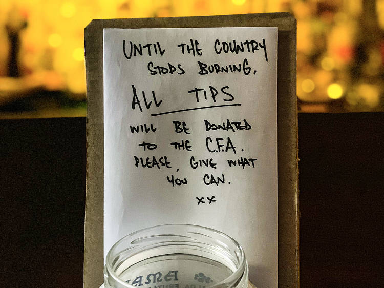 A tip jar and a handwritten note saying "until the country stops burning, all tips will be donated the CFA. Please give what you can".