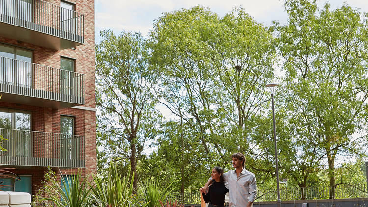 exterior of apartment building with two people walking